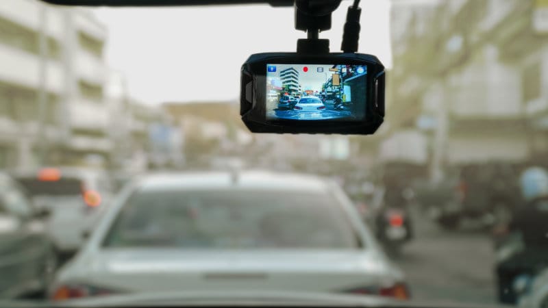 Photo of a car dashcam mounted to the windscreen.