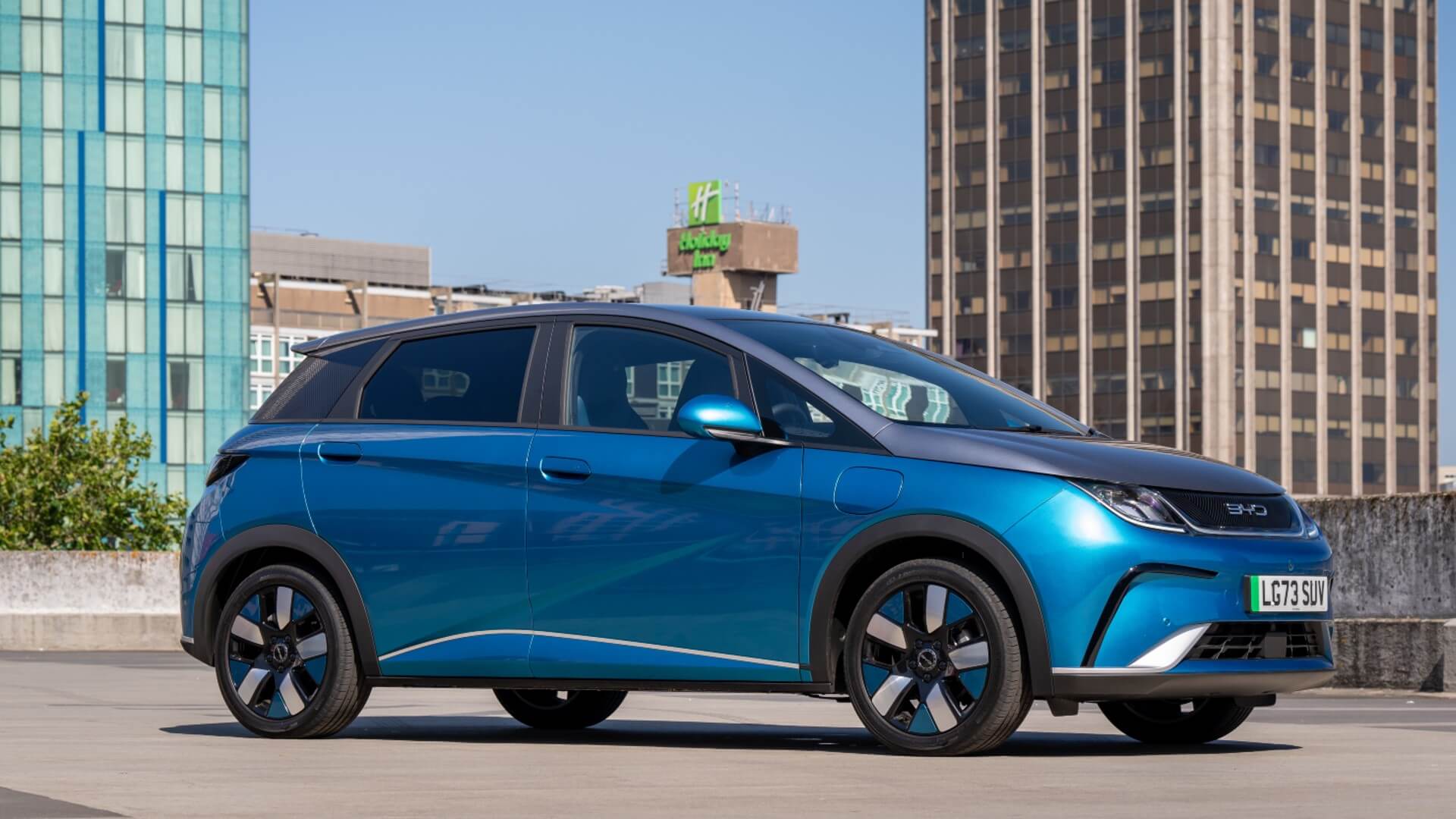 Blue BYD Dolphin parked on rooftop with skyline