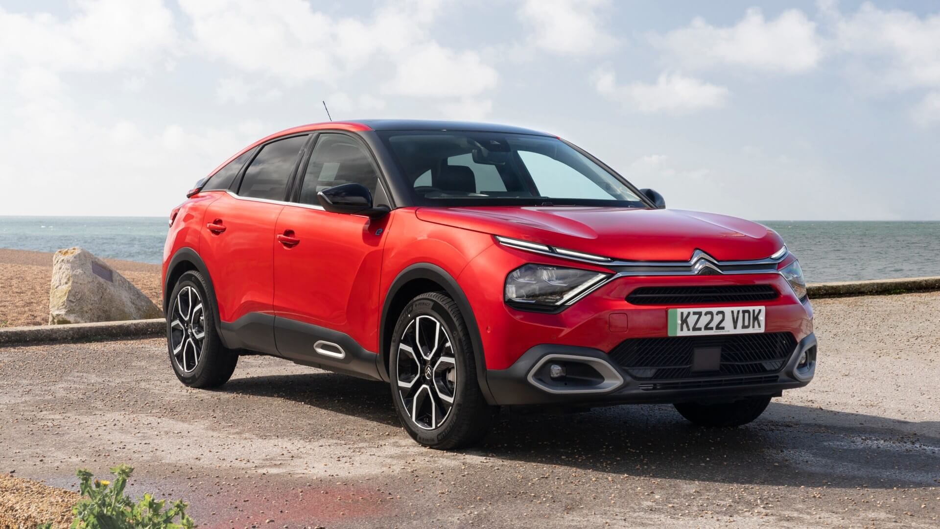 Red Citroen E-C4 parked by water