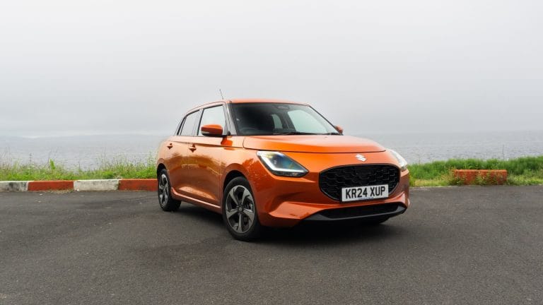 Solar Orange Suzuki Swift hybrid, parked.