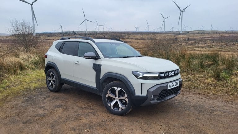 Image of the 2024 Dacia Duster Journey parked on a wind farm.