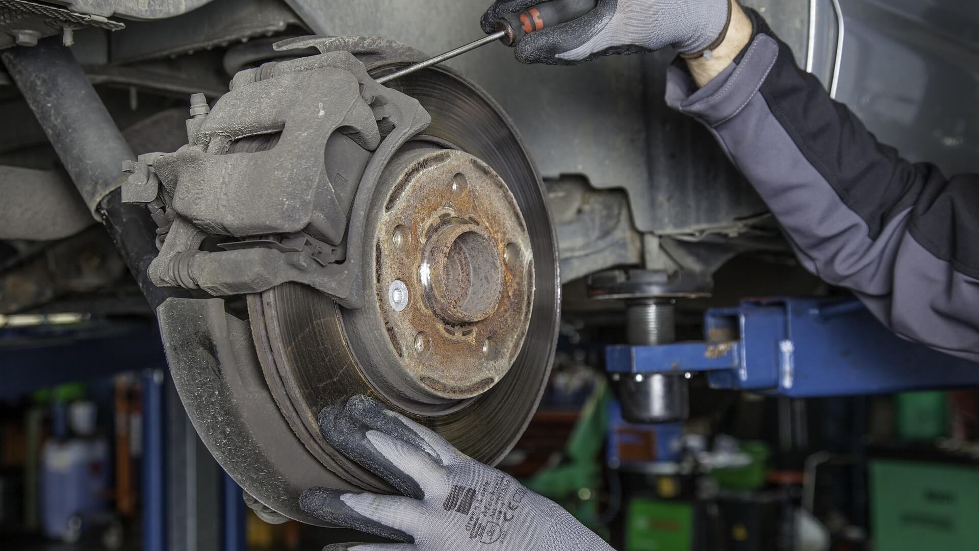 Image of a mechanic replacing brake pads on a car.