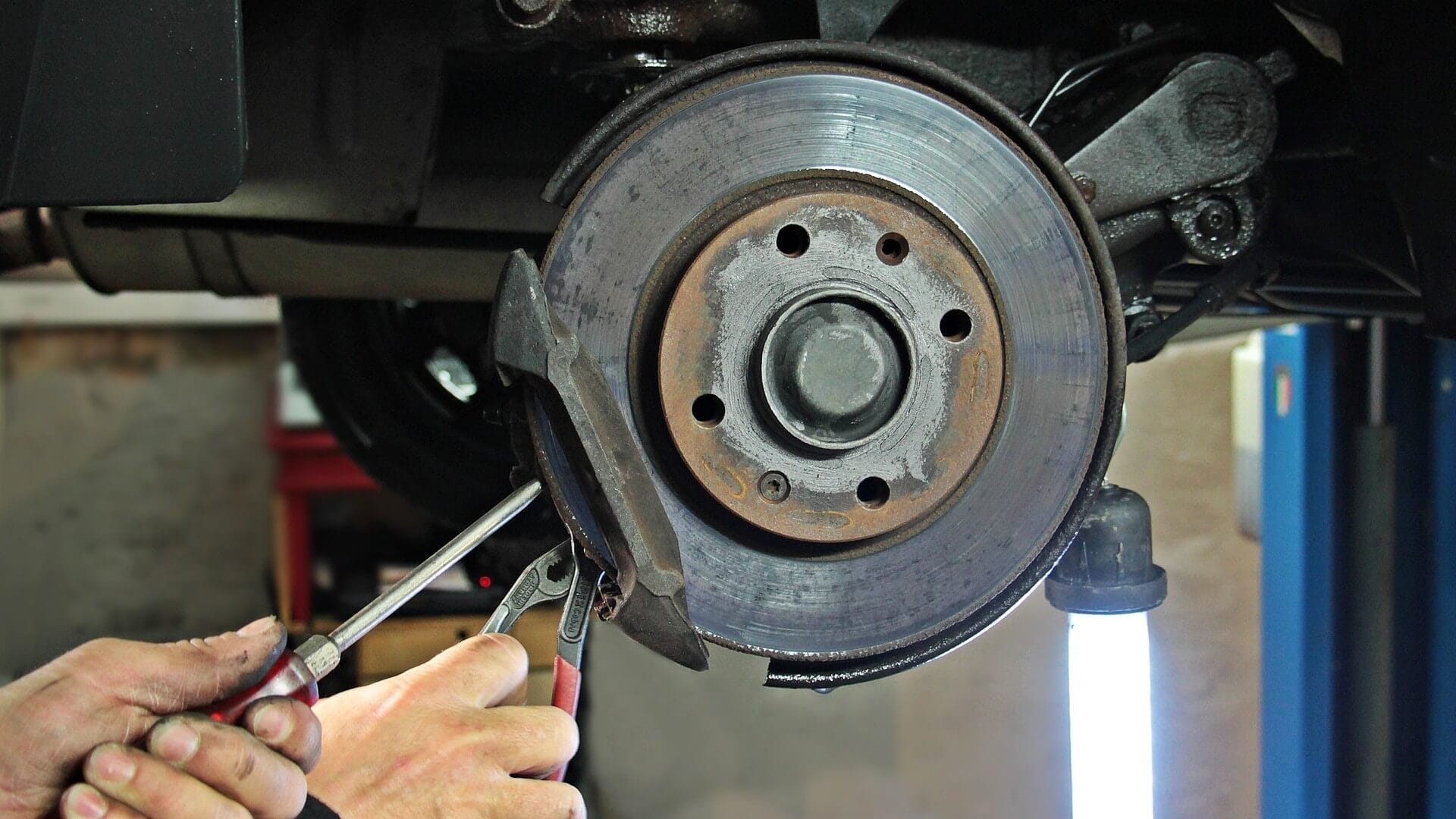 Image of a mechanic changing brake pads.