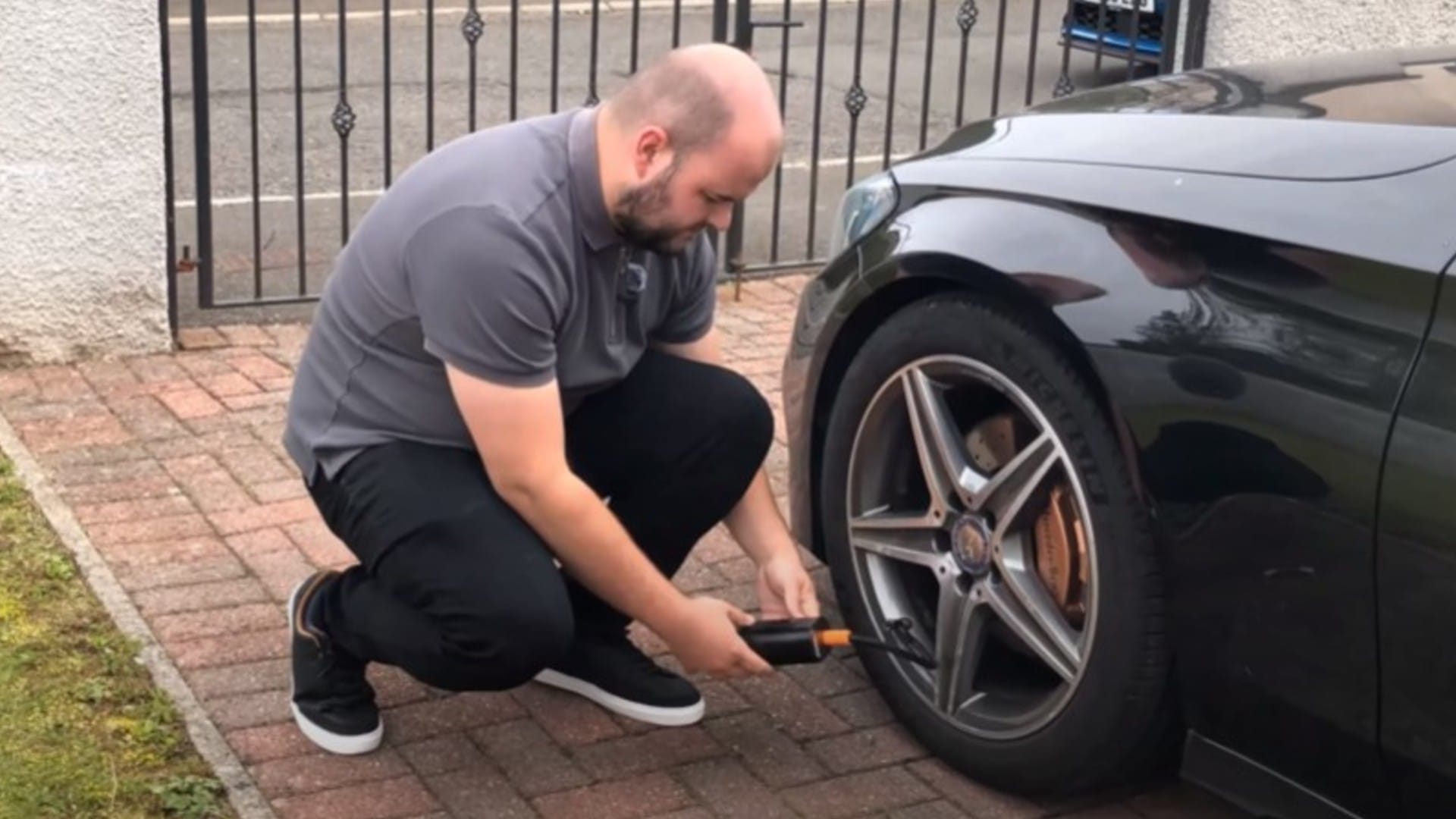 Dylan inflating a tyre with a portable tyre inflator.
