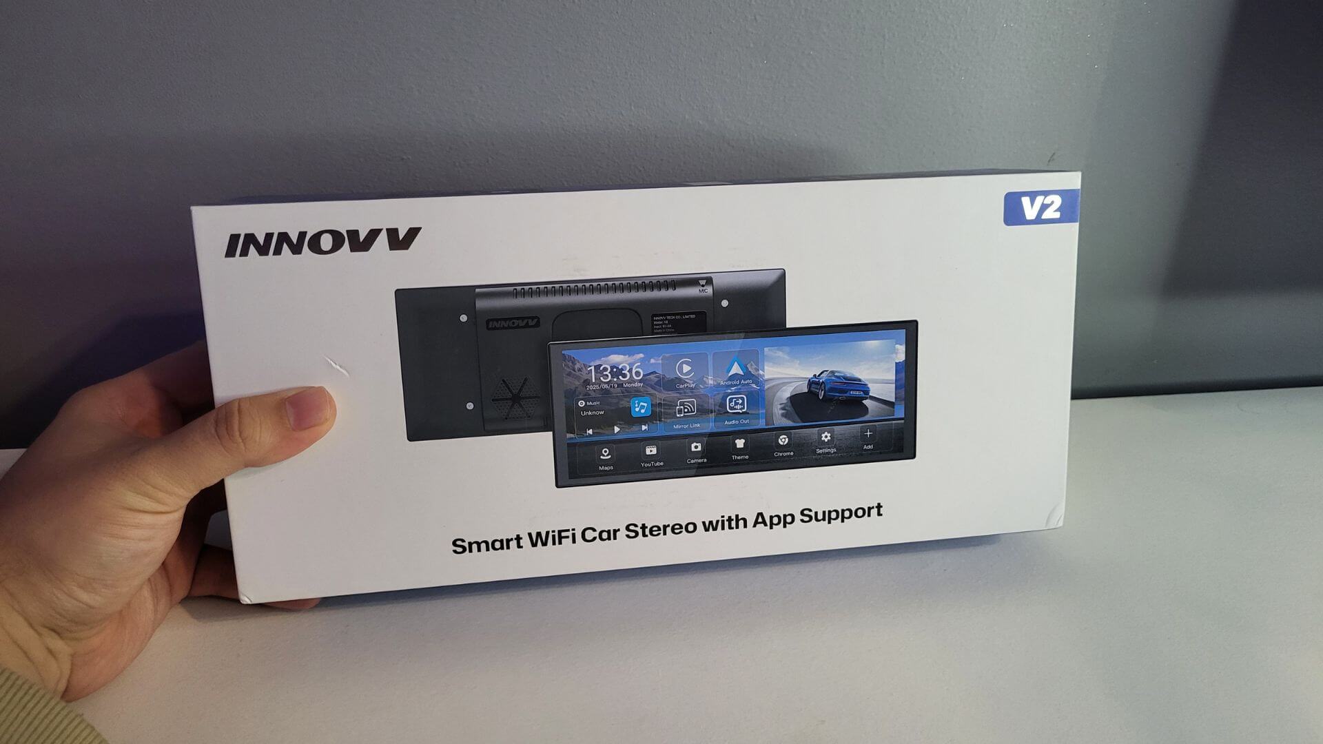 Dylan Freeburn holding the INNOVV V2 CarPlay screen.